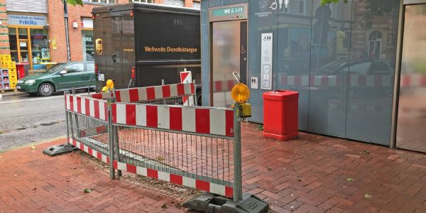 Die seit Monaten vor der Toilette stehende Baustellenabsperrung. Foto: André Zand-Vakili Toilette am Rathausplatz: Hässliche Absperrung soll verschwinden