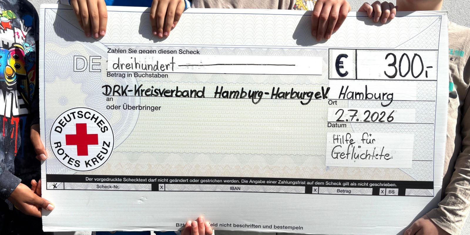 Eine Spende in Höhe von 300 Euro, selbst eingenommen über den Verkauf von Kuchen an ihrer Schule, überreichten vier Kinder der Grundschule Georg-Kerschensteiner jetzt an das DRK.  Foto: DRK Hamburg-Harburg 2026