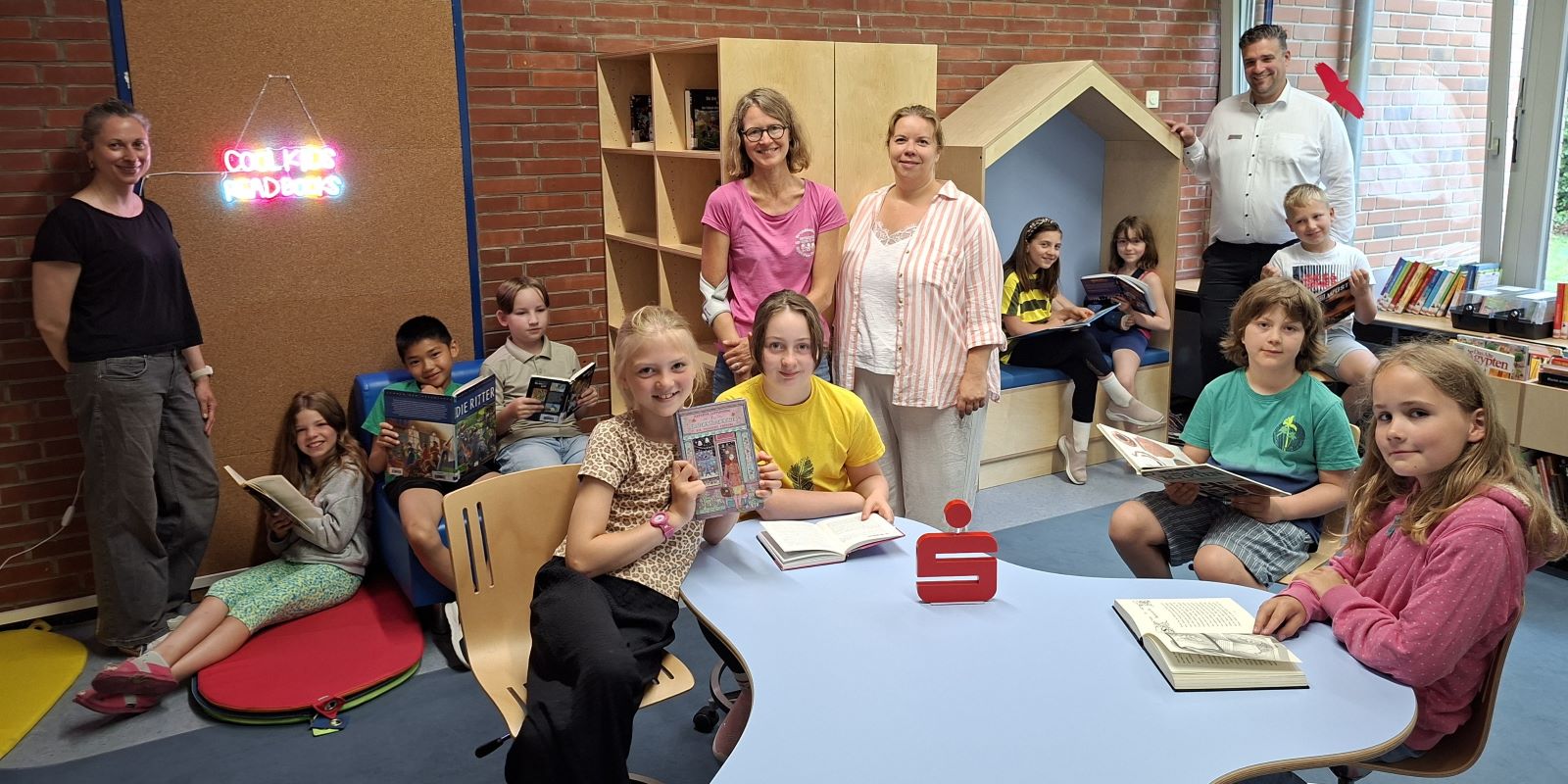 Die Schülerinnen und Schüler des 3. Jahrgangs lesen endlich wieder in ihrer neumöblierten Schulbibliothek. Mit dabei (von links): Julia Geiß (Lesemutter), Barbara Findeklee-Walter (Schulleiterin), Meike Meyer (Lesemutter) und Peter Wist (stellvertretender Regionalleiter Buchholz/Rosengarten der Sparkasse Harburg-Buxtehude).