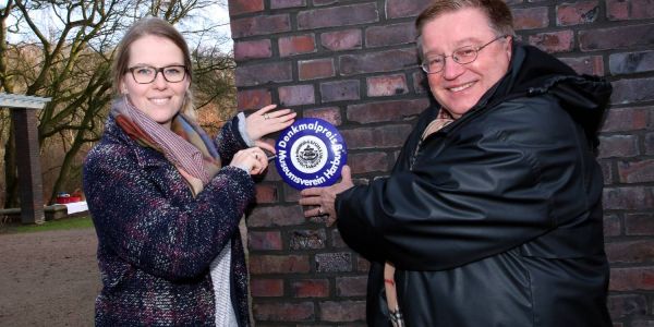 Der große Moment: Viktoria Ehlers von der FDP und Peter Hornberger vom Museumsverein bringen die Plakette am Marmstorfer Eingangs zum Harburger Stadtpark an. Foto: Christian Bittcher Denkmalpreis: Auszeichnung für sanierten Stadtpark-Eingang