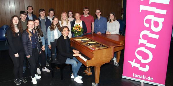 Nachwuchs-Pianist Aurel Dawidiuk mit dem Organisationsteam der Tonali-Konzerte in der Pausenhalle des Heisenberg-Gymnasiums Foto: Christian Bittcher Pausenhalle als Konzertsaal: Aurel Dawidiuk begeistert 800 Schüler