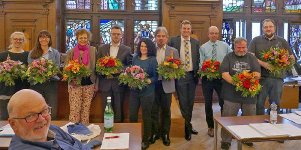 Bezirksversammlungs-Vizepräsident Robert Timmann (Mitte, ohne Blumen) mit den nicht mehr Kandidierenden (von links): Ronja Schmager, Tülin Akkoç, Katharina Gajewski, Carsten Schuster, Eftichia Olowson-Saviolaki, Harald Feineis, Florian Klein, André Lenthe und Jan-Philipp Schucher. Nicht im Bild: Pinar Esir und Martin Çelik. Im Vordergrund: Torsten Fuß. Er kandidiert wieder. Foto: mag Bezirksversammlung beendete ihre „besonders ereignisreiche Legislatur“