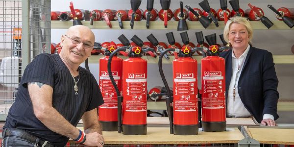 Peter Sebastian und Nicole Maack im Lager von Maack-Feuerschutz. Foto: André Zand-Vakili Große Freude über einen Scheck für unfallgeschädigte Kinder