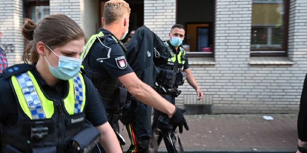 Polizisten führen den 19-Jährigen, der sich eine Jacke über den Kopf gezogen hat, nach dessen Festnahme ab. Foto: André Lenthe - Fotografie Phoenix-Viertel: 16-Jähriger offenbar aus Wut und Rache niedergestochen