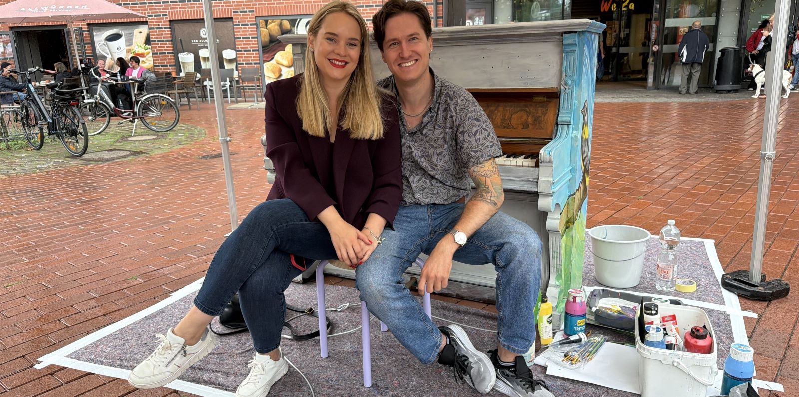 Citymanagerin Antonia Marmon und Künstler Ralf Schwinge an einem der Klaviere. Foto: Harburg Marketing 