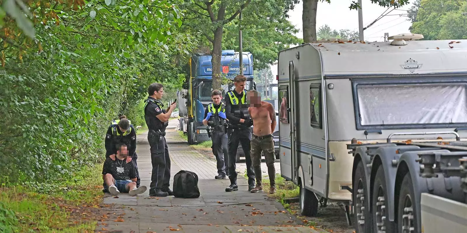 Polizisten haben die beiden Männer festgesetzt, überprüfen ihre Personalien. Foto: Lenthe-Medien