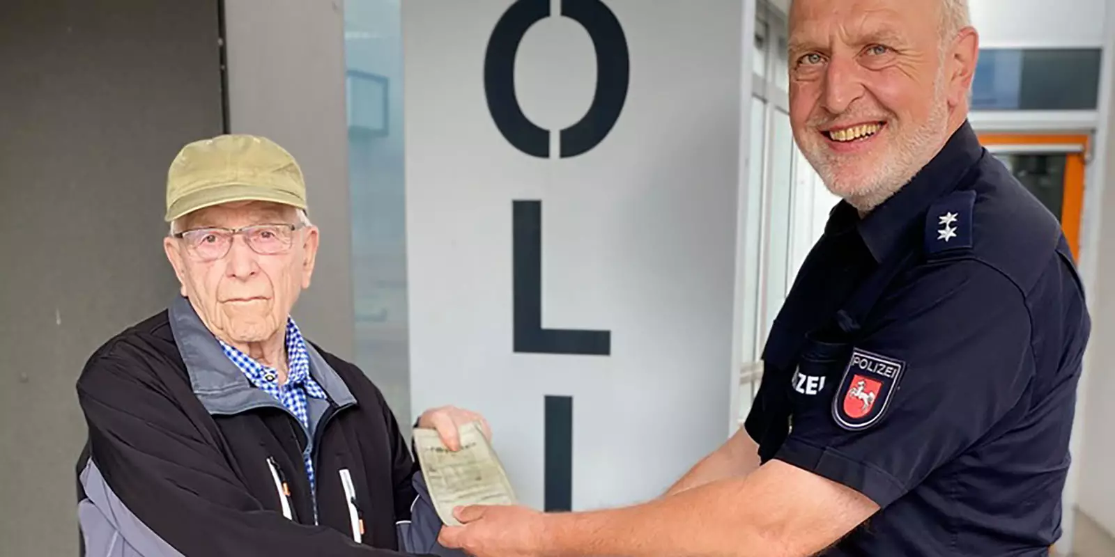 Walter Dahl übergibt Dirk Poppinga seinen Führerschein. Foto: Polizei