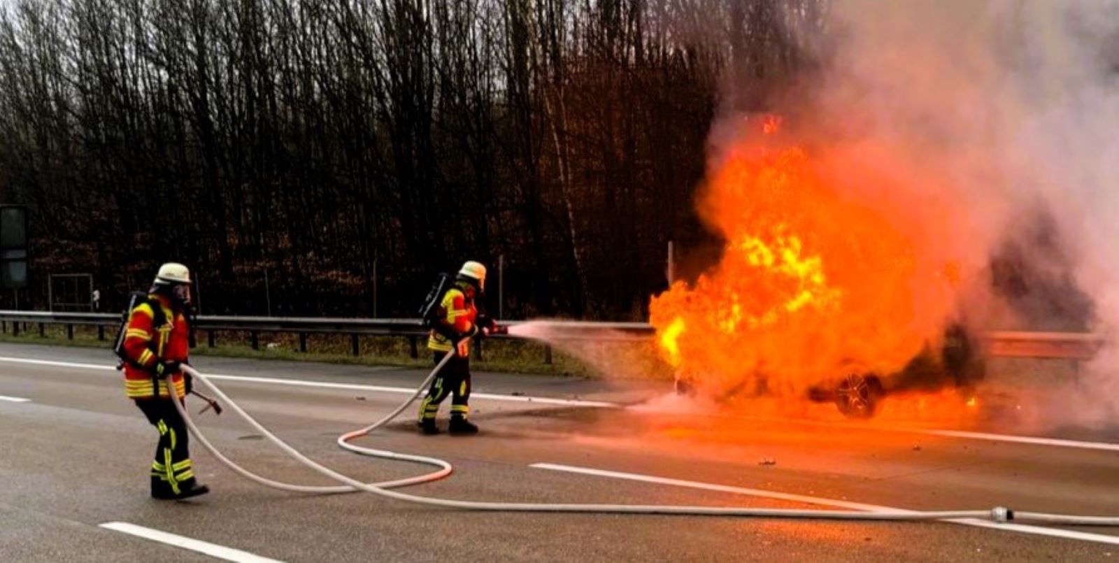 Auto auf der A7 in Flammen: Zwei der eingesetzten Feuerwehrleute aus den beiden Feuerwehren gingen unter Atemschutz zur Brandbekämpfung vor. Foto: Stephan Maack, FF Ohlendorf