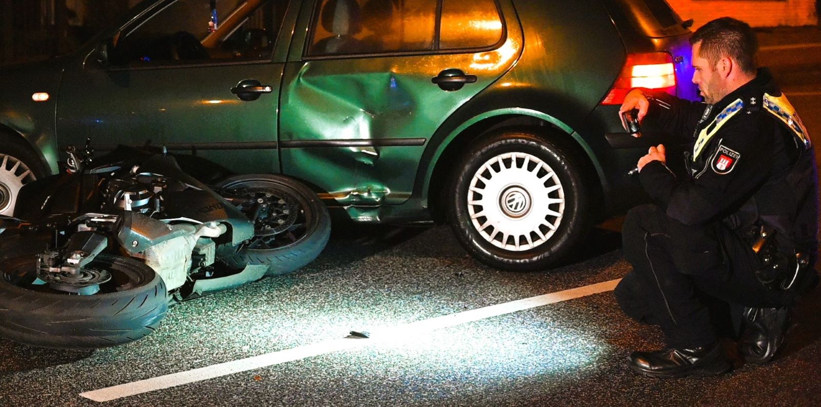 Ein Polizist untersucht die Unfallstelle auf der Winsener Straße. Foto: Lenthe-Medien