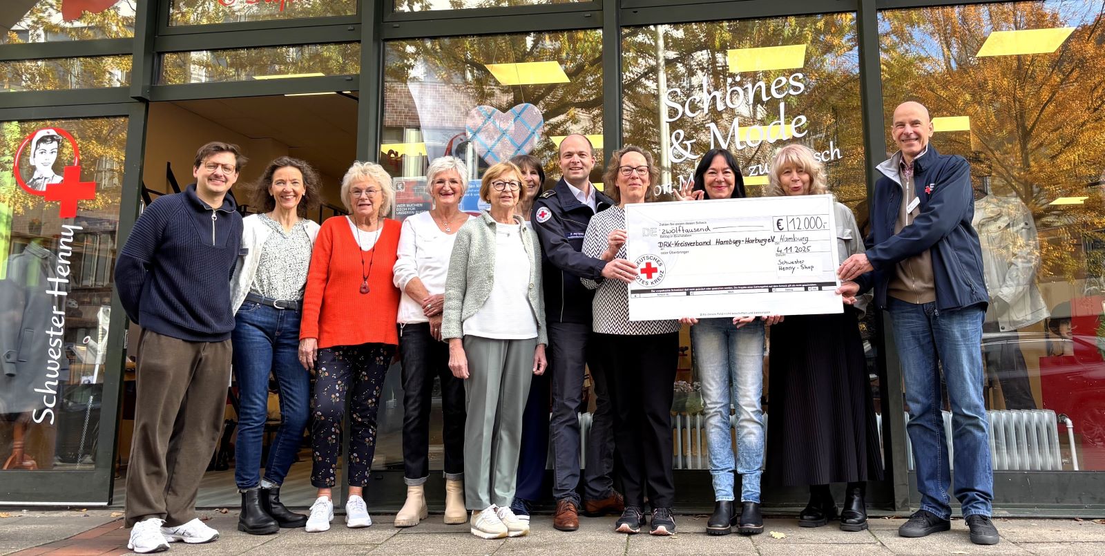 Das Team von "Schwester Henny" mit den Vertretern der bedachten DRK-Projekte vor dem Shop am Harburger Ring 8-10. Foto: DRK-Harburg